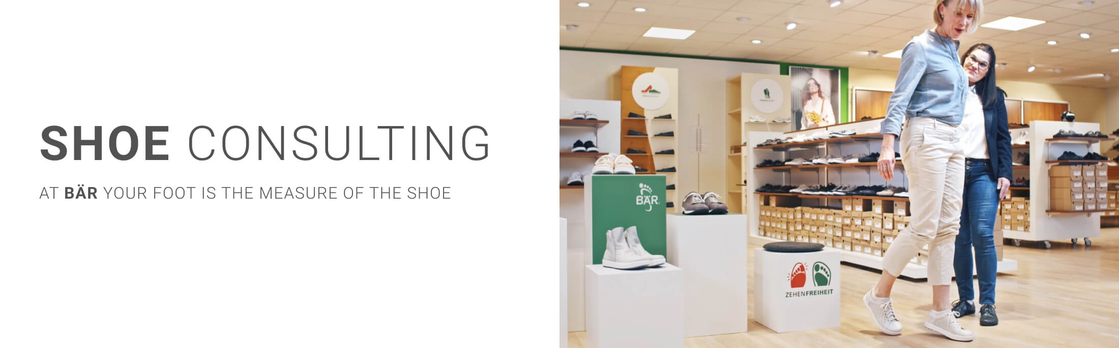 Two women engaging in a shoe consultation at BÄR, surrounded by various shoe displays inside a store.