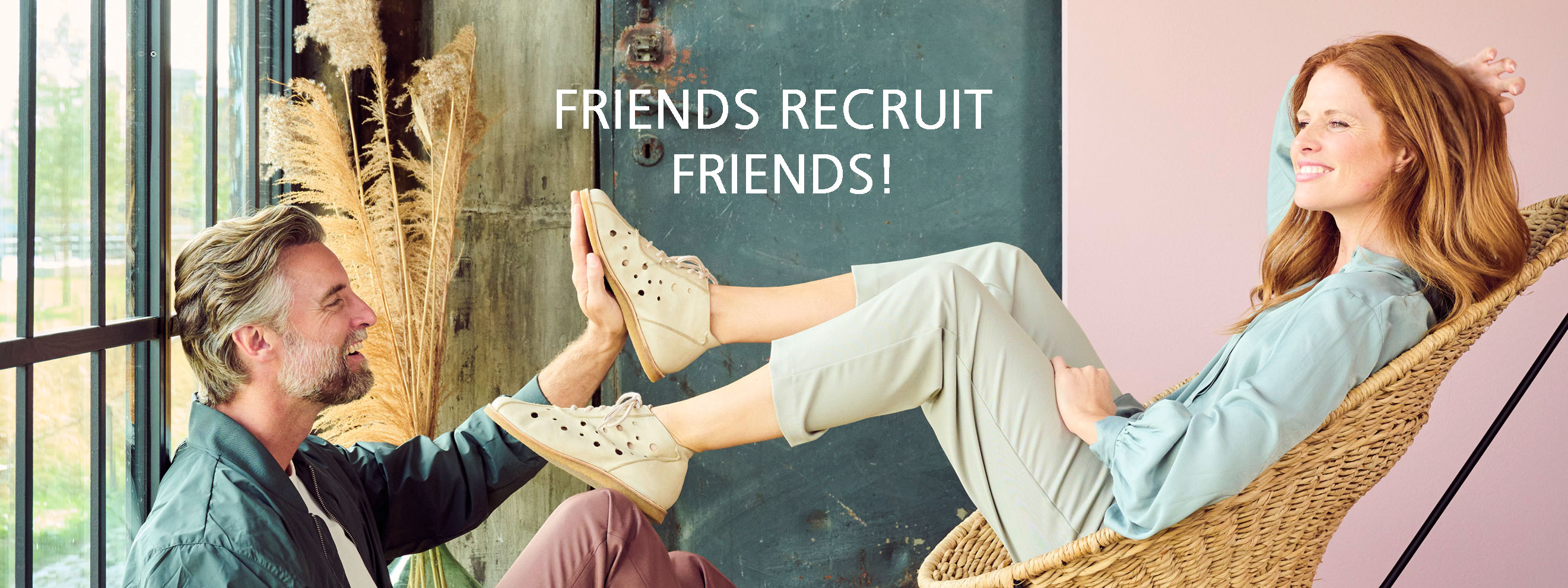 Man and woman enjoying a relaxed moment with smiles, promoting friends recruitment program.